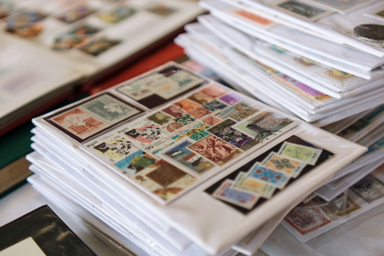 hero-img-01 A detailed collection of vintage postage stamps neatly organized in albums, showcasing diverse themes.